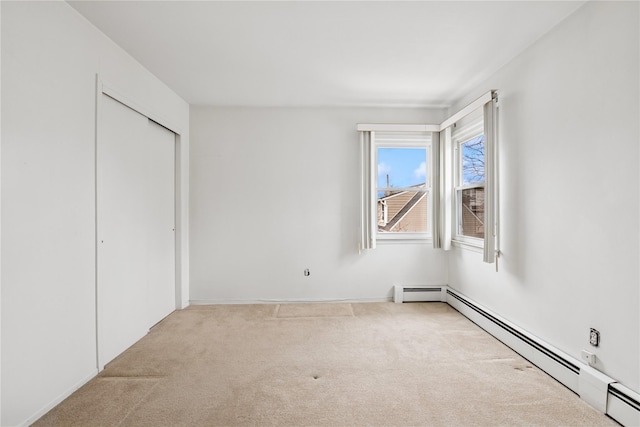 unfurnished bedroom featuring a baseboard heating unit, a closet, and carpet