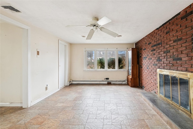 unfurnished living room with a baseboard heating unit, stone finish flooring, a brick fireplace, and visible vents