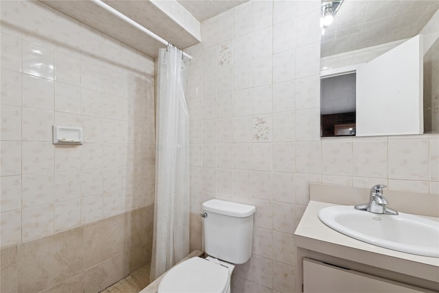 full bathroom with toilet, a tile shower, tile walls, and vanity