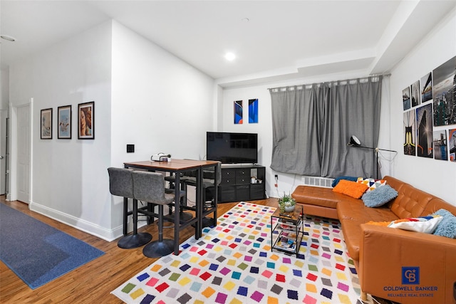 living room with recessed lighting, visible vents, baseboards, and wood finished floors