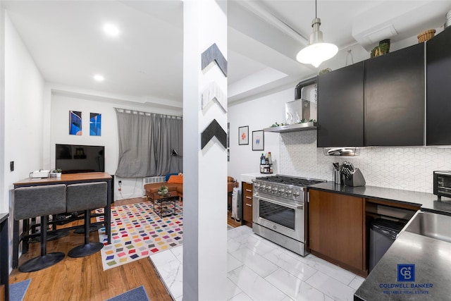 kitchen featuring tasteful backsplash, dark countertops, marble finish floor, and high end stainless steel range oven