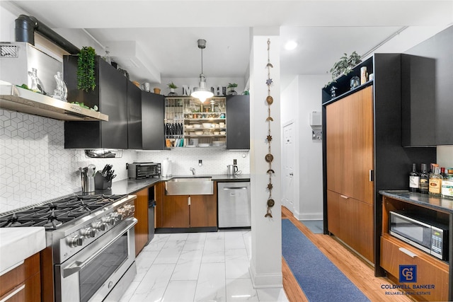 kitchen featuring open shelves, appliances with stainless steel finishes, a sink, and tasteful backsplash