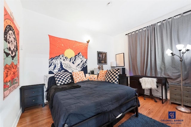 bedroom with baseboards and wood finished floors