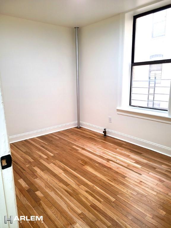 empty room with baseboards and wood finished floors