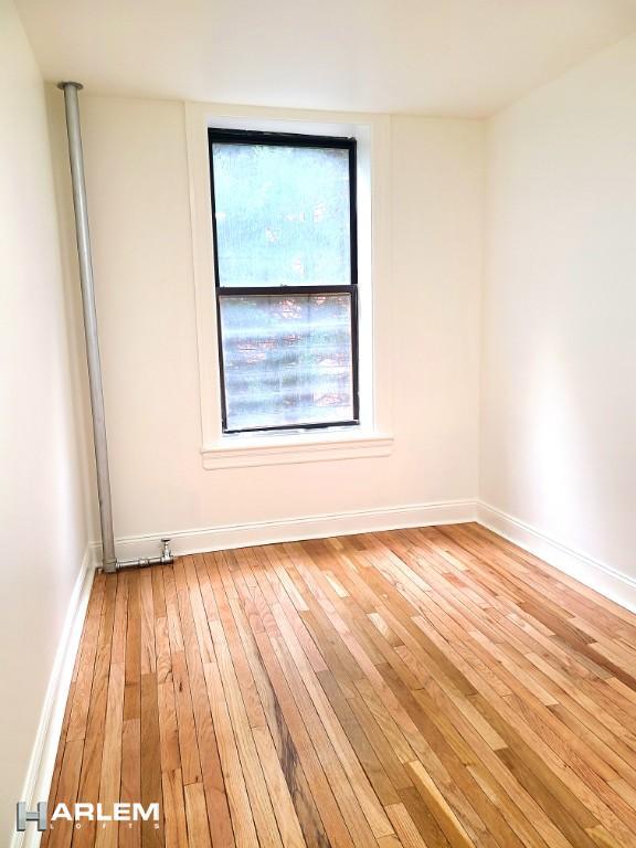 unfurnished room featuring light wood-type flooring and baseboards