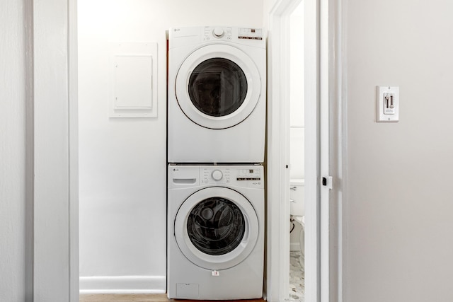 clothes washing area with laundry area and stacked washing maching and dryer