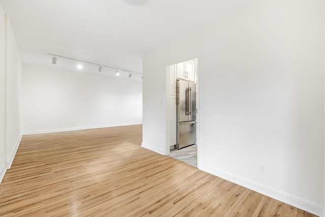 unfurnished room featuring baseboards and light wood-type flooring