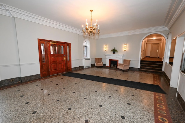 entryway featuring arched walkways, granite finish floor, an inviting chandelier, ornamental molding, and wainscoting