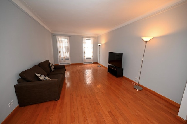 unfurnished living room with light wood-style floors, ornamental molding, and baseboards