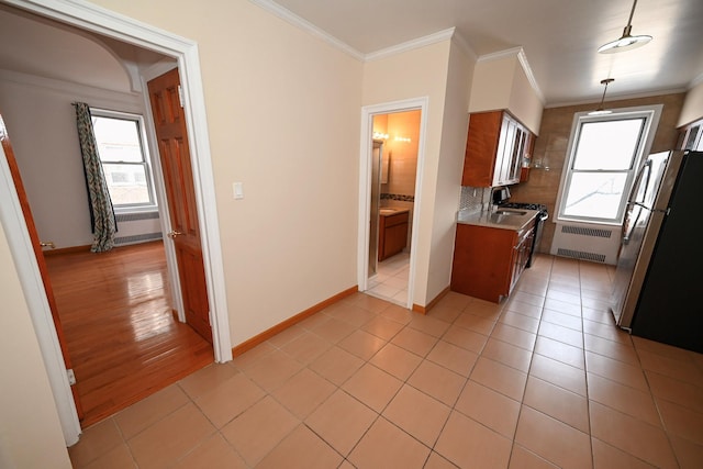 kitchen with a wealth of natural light, freestanding refrigerator, radiator, and light countertops