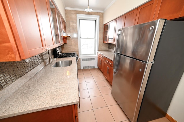 kitchen with radiator, backsplash, stainless steel appliances, and crown molding