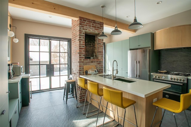 kitchen with hanging light fixtures, premium appliances, a sink, light countertops, and a kitchen breakfast bar