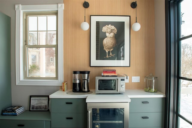 bar featuring stainless steel microwave, plenty of natural light, and wine cooler