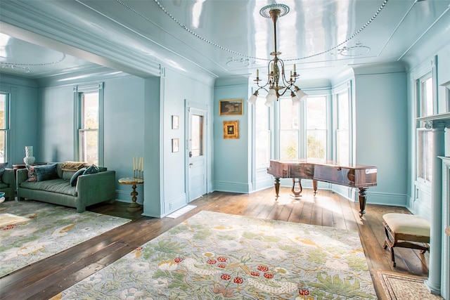 interior space featuring crown molding, a notable chandelier, baseboards, and hardwood / wood-style flooring