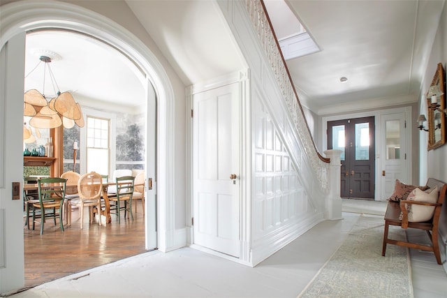 entryway with arched walkways and crown molding