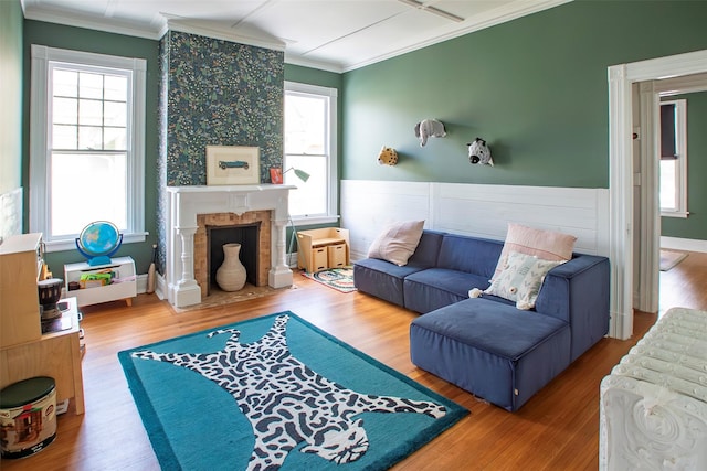 living room featuring a fireplace, wood finished floors, and a healthy amount of sunlight
