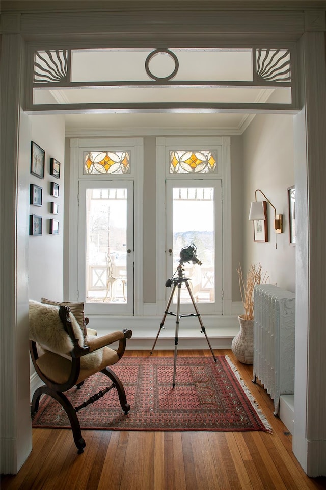 living area with crown molding and wood finished floors