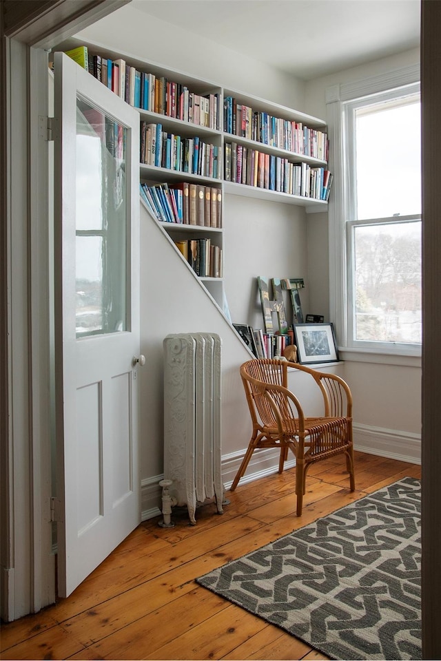 living area with wood-type flooring and baseboards