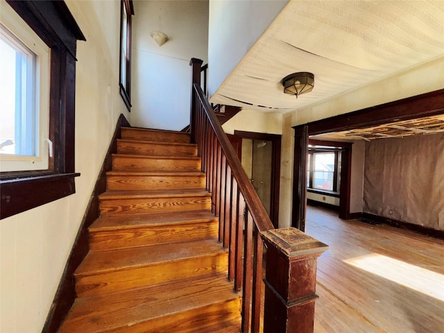 staircase with baseboards and wood finished floors