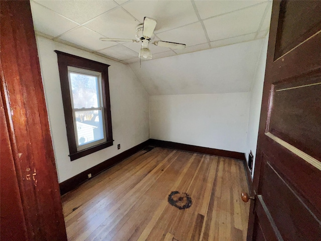 bonus room with lofted ceiling, visible vents, ceiling fan, baseboards, and hardwood / wood-style flooring