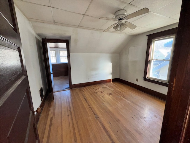 bonus room with light wood-style floors, lofted ceiling, visible vents, and baseboards