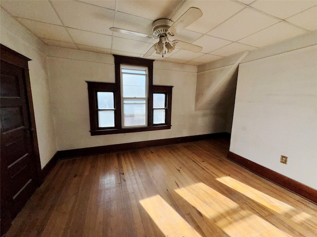 interior space featuring ceiling fan, hardwood / wood-style floors, a paneled ceiling, and baseboards