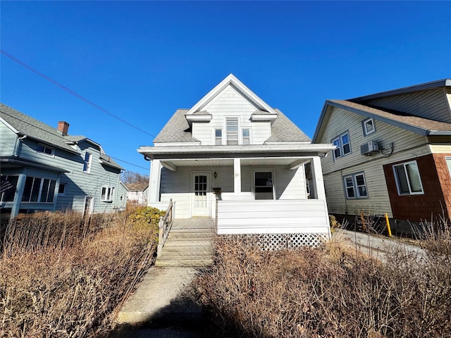 bungalow featuring a porch and roof with shingles