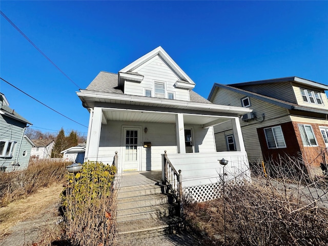 view of front of property with a porch and roof with shingles