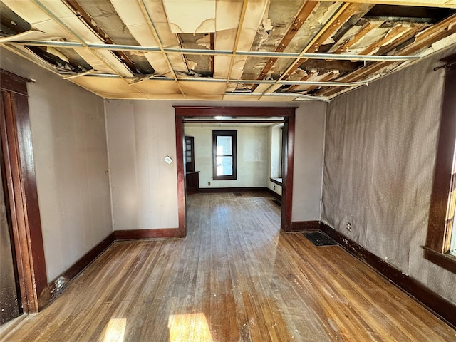 spare room featuring baseboards and hardwood / wood-style flooring