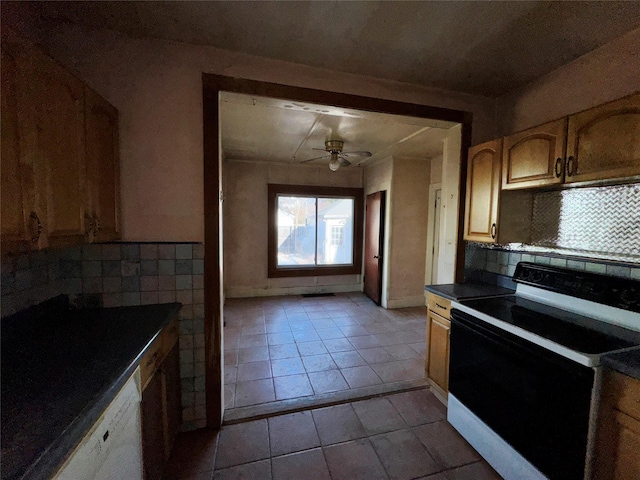 kitchen featuring ceiling fan, light tile patterned flooring, electric stove, backsplash, and dark countertops