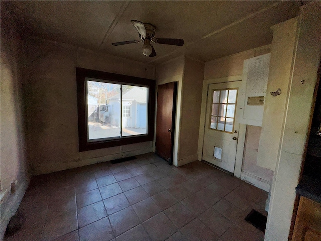 empty room featuring a ceiling fan and tile patterned floors