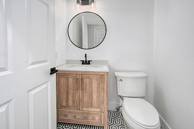 bathroom with baseboards, vanity, and toilet