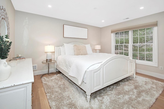 bedroom with light wood-style flooring, visible vents, baseboards, and recessed lighting