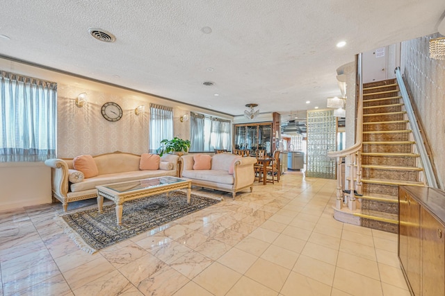 living area with a textured ceiling, recessed lighting, visible vents, marble finish floor, and stairway