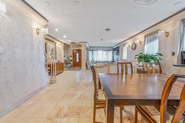 dining room with visible vents, a textured ceiling, and a textured wall