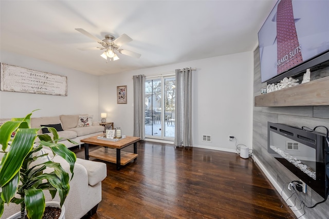 living room featuring a large fireplace, wood finished floors, visible vents, a ceiling fan, and baseboards