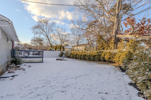 yard layered in snow with a wooden deck