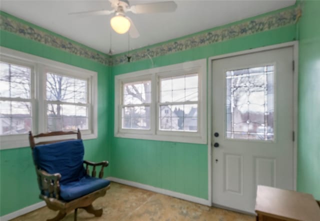 foyer entrance featuring baseboards and ceiling fan