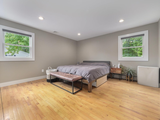 bedroom with recessed lighting, multiple windows, light wood-type flooring, and baseboards