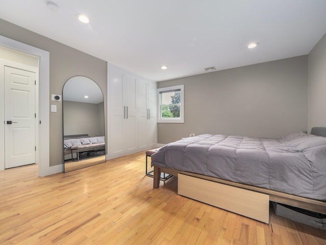 bedroom featuring light wood-type flooring, visible vents, baseboards, and recessed lighting