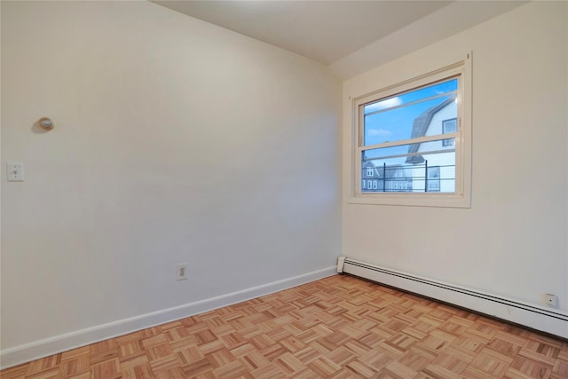 empty room featuring a baseboard radiator and baseboards