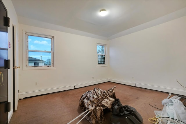 carpeted empty room featuring a baseboard heating unit, a wealth of natural light, and baseboards