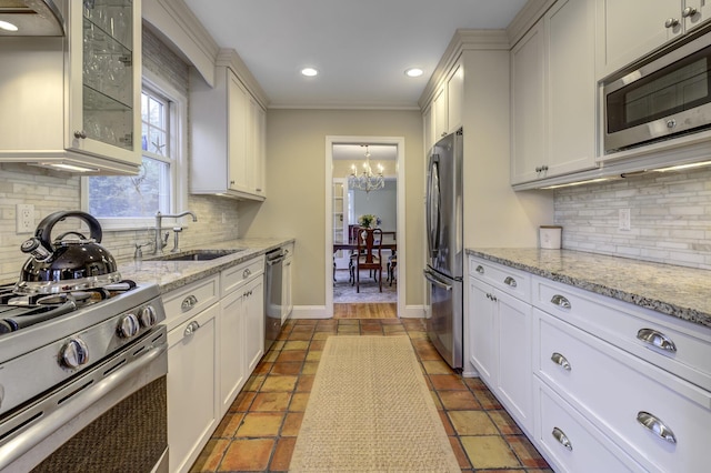 kitchen featuring glass insert cabinets, baseboards, recessed lighting, stainless steel appliances, and a sink