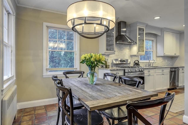 dining room featuring baseboards, a healthy amount of sunlight, ornamental molding, and radiator heating unit