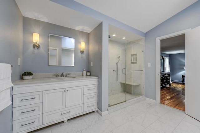 bathroom featuring baseboards, vanity, marble finish floor, and a shower stall