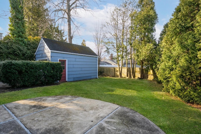 view of yard featuring a patio area, an outbuilding, and fence