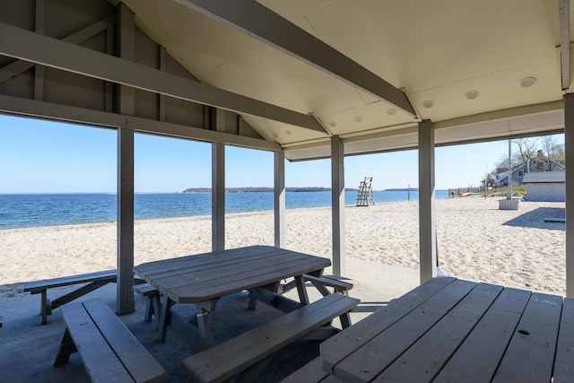 exterior space featuring outdoor dining space, a view of the beach, and a water view