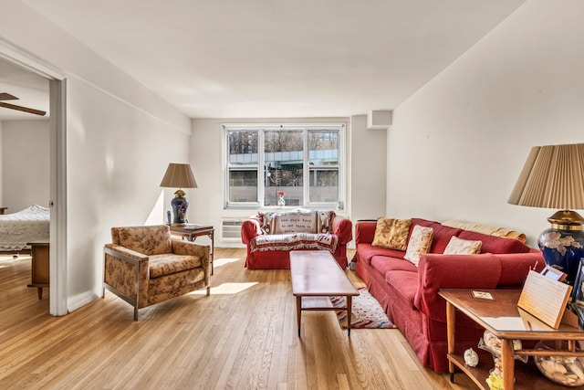 living area with light wood finished floors and a wall mounted AC