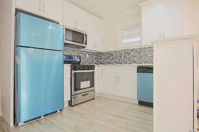 kitchen with stainless steel appliances, white cabinets, light wood finished floors, and tasteful backsplash