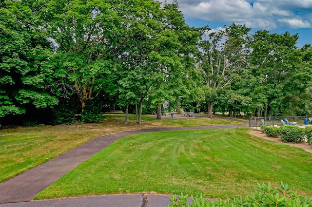 view of home's community featuring a lawn and fence